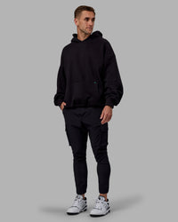 Man wearing Unisex We Rise Hoodie Oversize - Black-Impact Green | Thumbnail Index: 6
