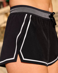 Woman wearing Accelerate 3" Reflective Mid-Rise Running Short - Black-Reflective | Model:Em | Size:S | Thumbnail Index: 2