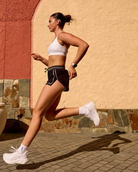 Woman wearing Accelerate 3" Reflective Mid-Rise Running Short - Black-Reflective | Model:Em | Size:S | Thumbnail Index: 1