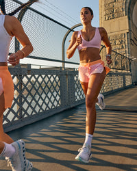 Woman wearing Accelerate 3" Mid-Rise Running Short - Cantaloupe-Marshmallow | Model:Olivia | Size:S | Thumbnail Index: 3
