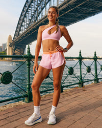 Woman wearing Accelerate 3" Mid-Rise Running Short - Cantaloupe-Marshmallow | Model:Olivia | Size:S | Thumbnail Index: 0