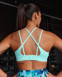 Woman wearing Aria Triangle Sports Bra - Island Paradise | Model:Rhiley | Size:S | Thumbnail Index: 0