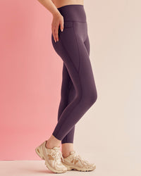 Woman wearing Elixir Ultra High-Rise 7/8 Legging Pockets - Midnight Plum | Model:Paradise | Size:S | Thumbnail Index: 0