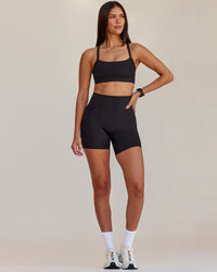Woman wearing Fusion V-Contour Ultra High-Rise 6" Short Pockets - Black | Model:Rhiley | Size:S | Thumbnail Index: 0