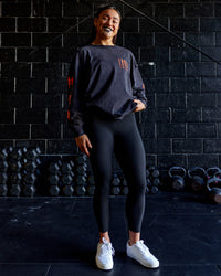 Woman wearing Inferno Journey FLXCotton Oversized Long Sleeve Tee - Washed Black-Ultra Orange | Model:Teraipine | Size:M | Thumbnail Index: 1