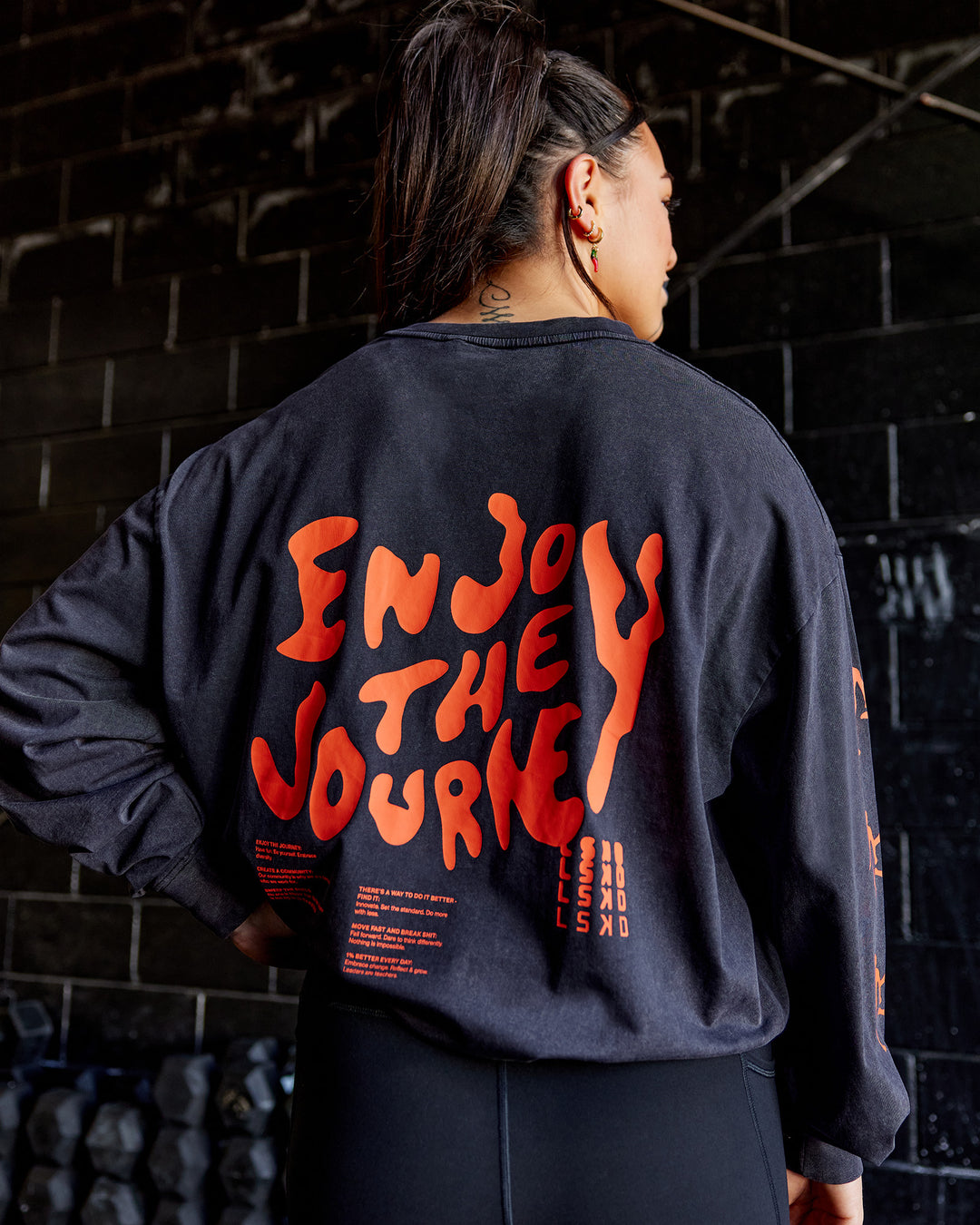 Woman wearing Inferno Journey FLXCotton Oversized Long Sleeve Tee - Washed Black-Ultra Orange | Model:Teraipine | Size:M - view 3