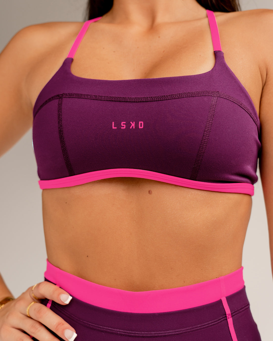 Woman wearing Liberate Sports Bra - Plum Caspia-Ultra Pink | Model:Jordi | Size:S - view 1