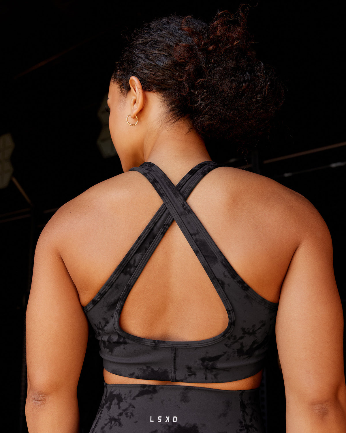 Woman wearing Stamina Sports Bra - Black Tie Dye | Model:Tarnie | Size:S