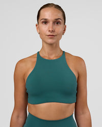 Woman wearing AMRAP High Neck Sports Bra - Transformative Teal | Model:Myrte | Size:S | Thumbnail Index: 0