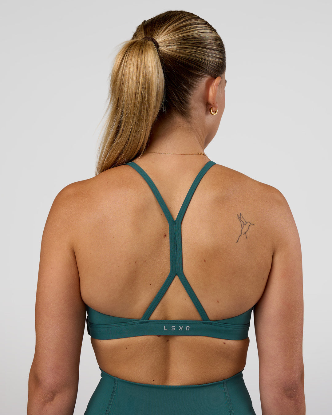 Woman wearing AMRAP High Neck Sports Bra - Transformative Teal | Model:Myrte | Size:S - view 2