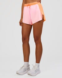 Woman wearing Accelerate 3" High-Rise Running Short - Cantaloupe-Marshmallow | Set:true | Angle:side | Model:Ruby | Size:S | Thumbnail Index: 4