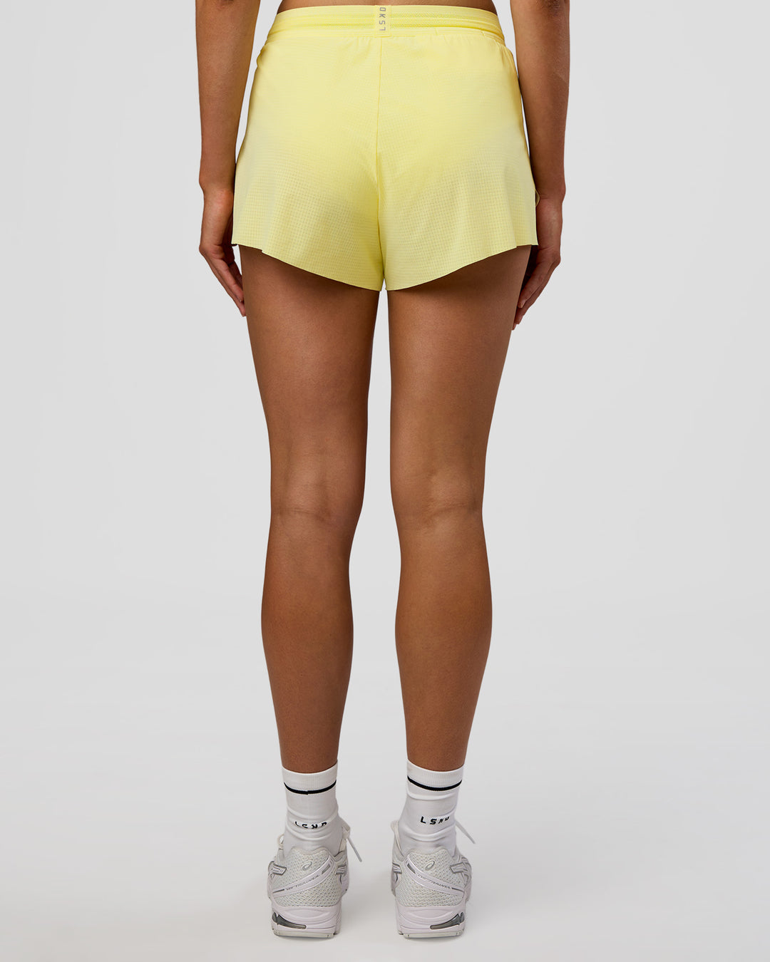 Woman wearing Accelerate 3" High-Rise Running Short - Yellow Fizz | Set:true | Angle:back | Model:Evie | Size:S - view 4