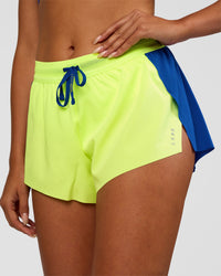 Woman wearing Accelerate 3" Mid-Rise Running Short - Electric Indigo-Lime Glo | Set:true | Angle:closeup | Model:Ruby | Size:S | Thumbnail Index: 0