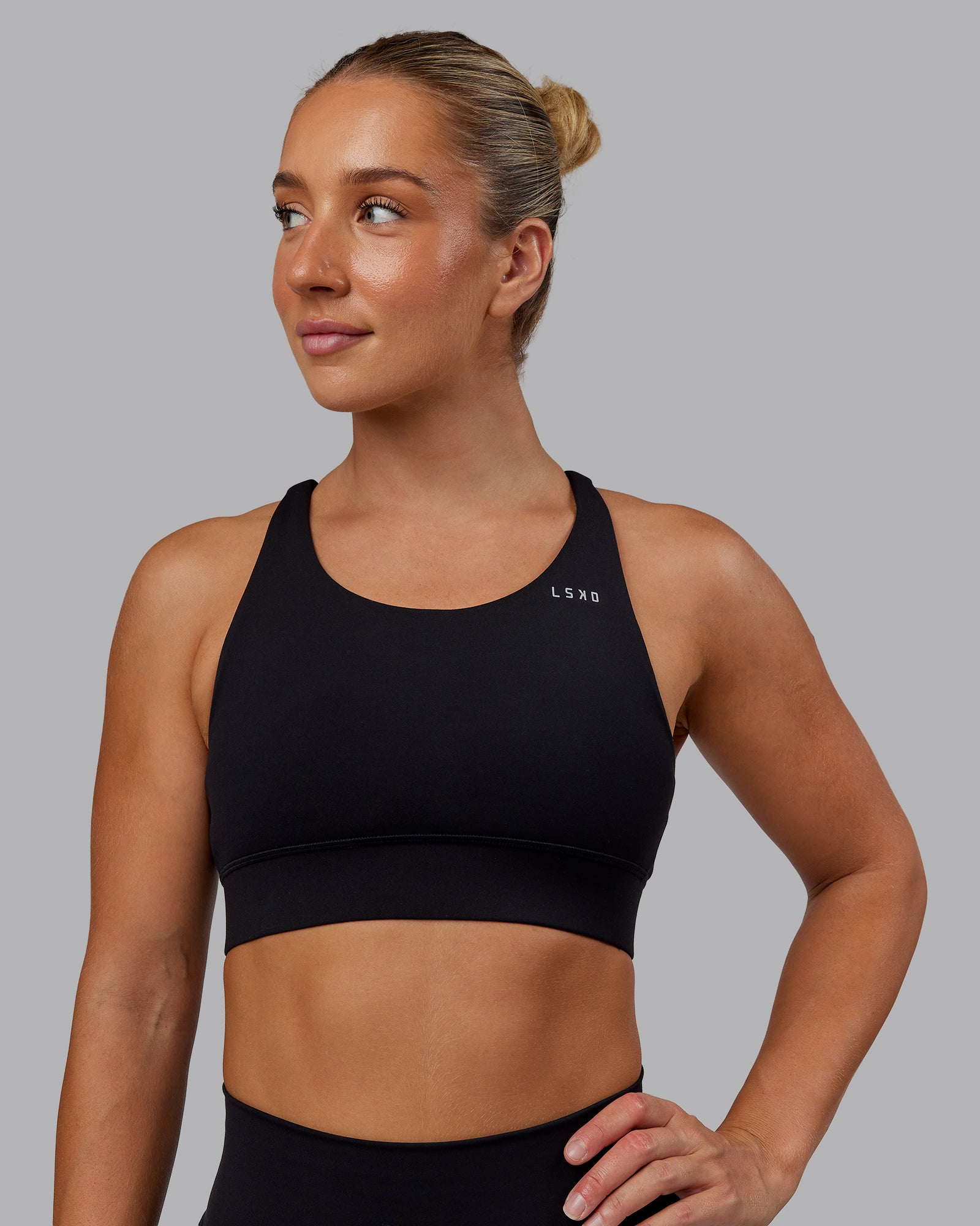 Woman wearing Accelerate Sports Bra - Black | Set:true | Angle:front | Model:Lyss | Size:S