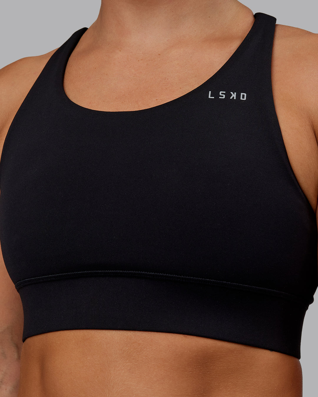 Woman wearing Accelerate Sports Bra - Black | Set:true | Angle:closeup | Model:Lyss | Size:S - view 4