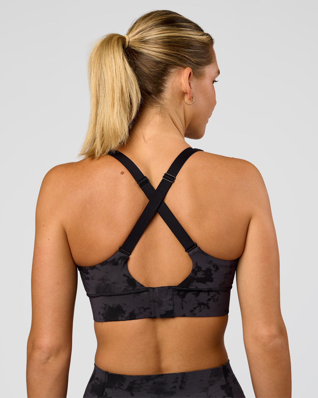 Woman wearing Accelerate Sports Bra - Black Tie Dye | Set:true | Angle:back | Model:Amity | Size:S - view 5
