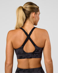 Woman wearing Accelerate Sports Bra - Black Tie Dye | Set:true | Angle:back | Model:Amity | Size:S | Thumbnail Index: 4