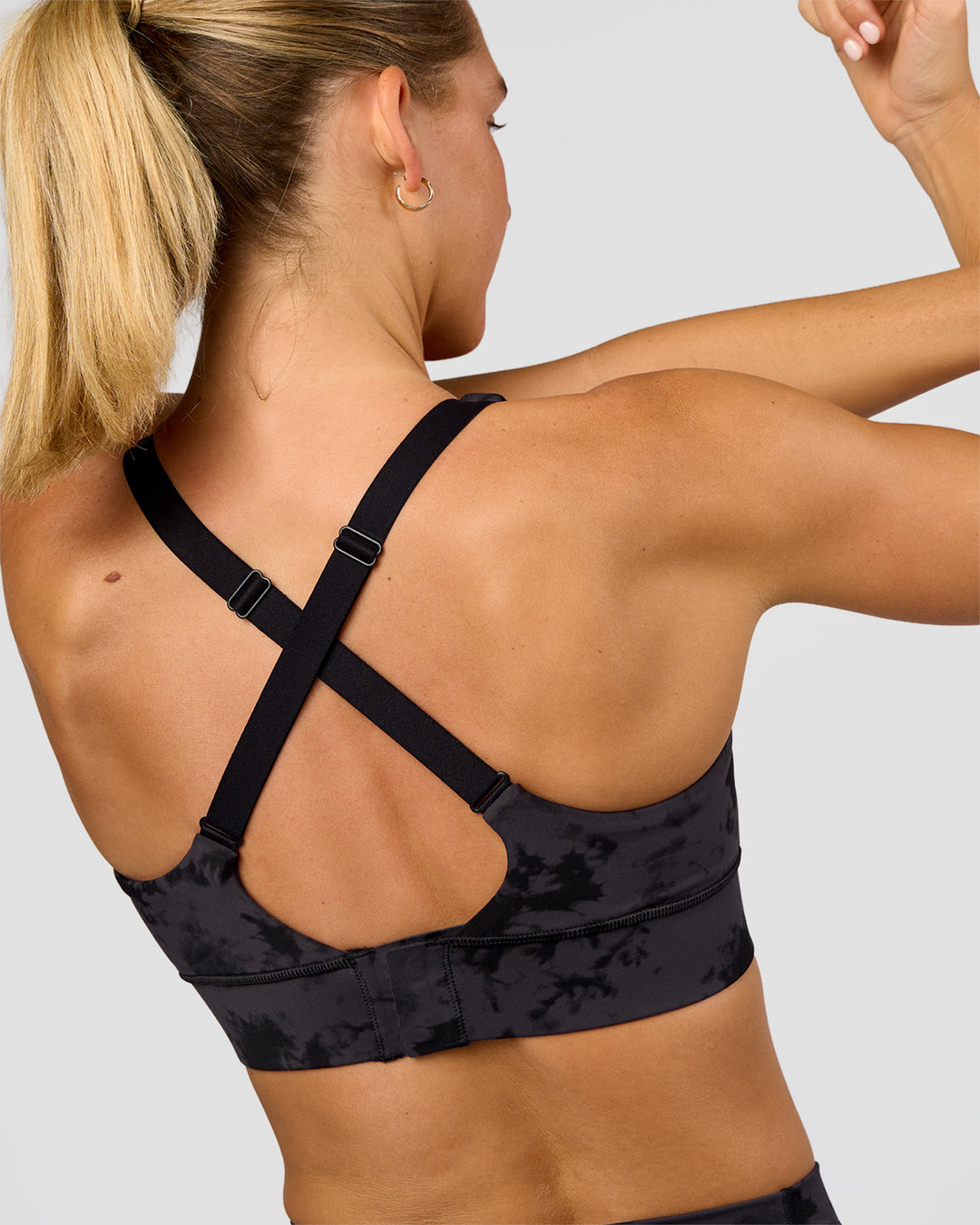 Woman wearing Accelerate Sports Bra - Black Tie Dye | Model:Amity | Size:S - view 2