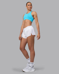 Woman wearing Accelerate Sports Bra - Blue Atoll | Model:Sophie | Size:S | Thumbnail Index: 2