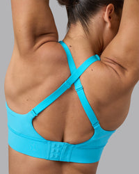 Woman wearing Accelerate Sports Bra - Blue Atoll | Model:Sophie | Size:S | Thumbnail Index: 1