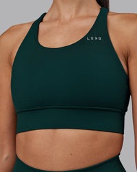 Woman wearing Accelerate Sports Bra - Dark Moss | Set:true | Angle:closeup | Model:Rhiley | Size:S | Thumbnail Index: 4