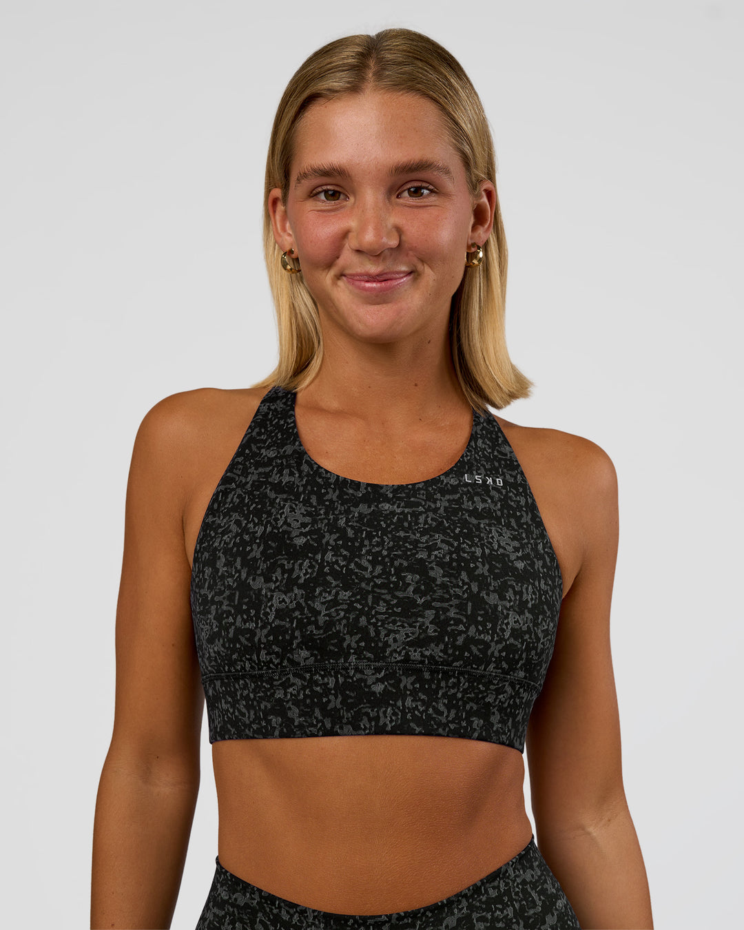 Woman wearing Accelerate Sports Bra - Energy Print Black | Set:true | Angle:front | Model:Amity | Size:S - view 1
