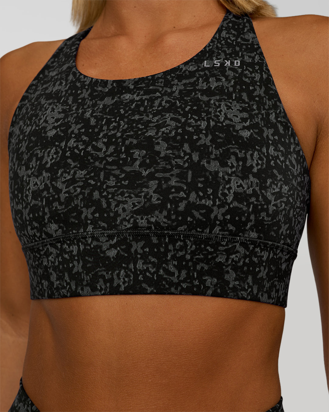 Woman wearing Accelerate Sports Bra - Energy Print Black | Set:true | Angle:closeup | Model:Amity | Size:S - view 4