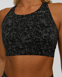 Woman wearing Accelerate Sports Bra - Energy Print Black | Set:true | Angle:closeup | Model:Amity | Size:S | Thumbnail Index: 3