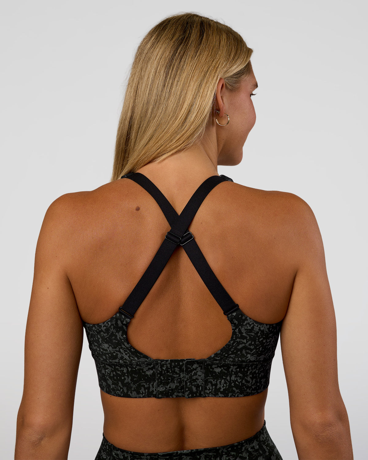 Woman wearing Accelerate Sports Bra - Energy Print Black | Set:true | Angle:back | Model:Amity | Size:S