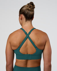 Woman wearing Accelerate Sports Bra - Transformative Teal | Set:true | Angle:back | Model:Sav | Size:S | Thumbnail Index: 1