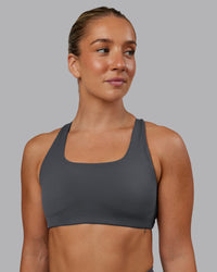 Woman wearing Aspire Sports Bra in Dark Storm | Size:S | Thumbnail Index: 1