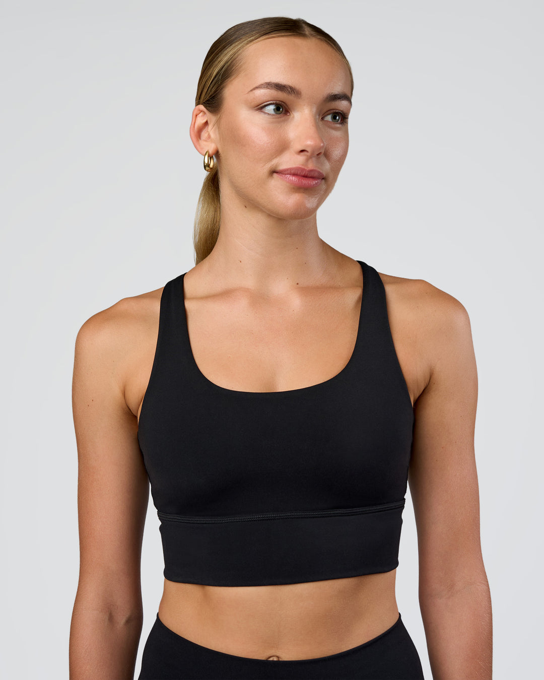 Woman wearing Circuit Longline Sports Bra - Black | Model:Evie | Size:S - view 1