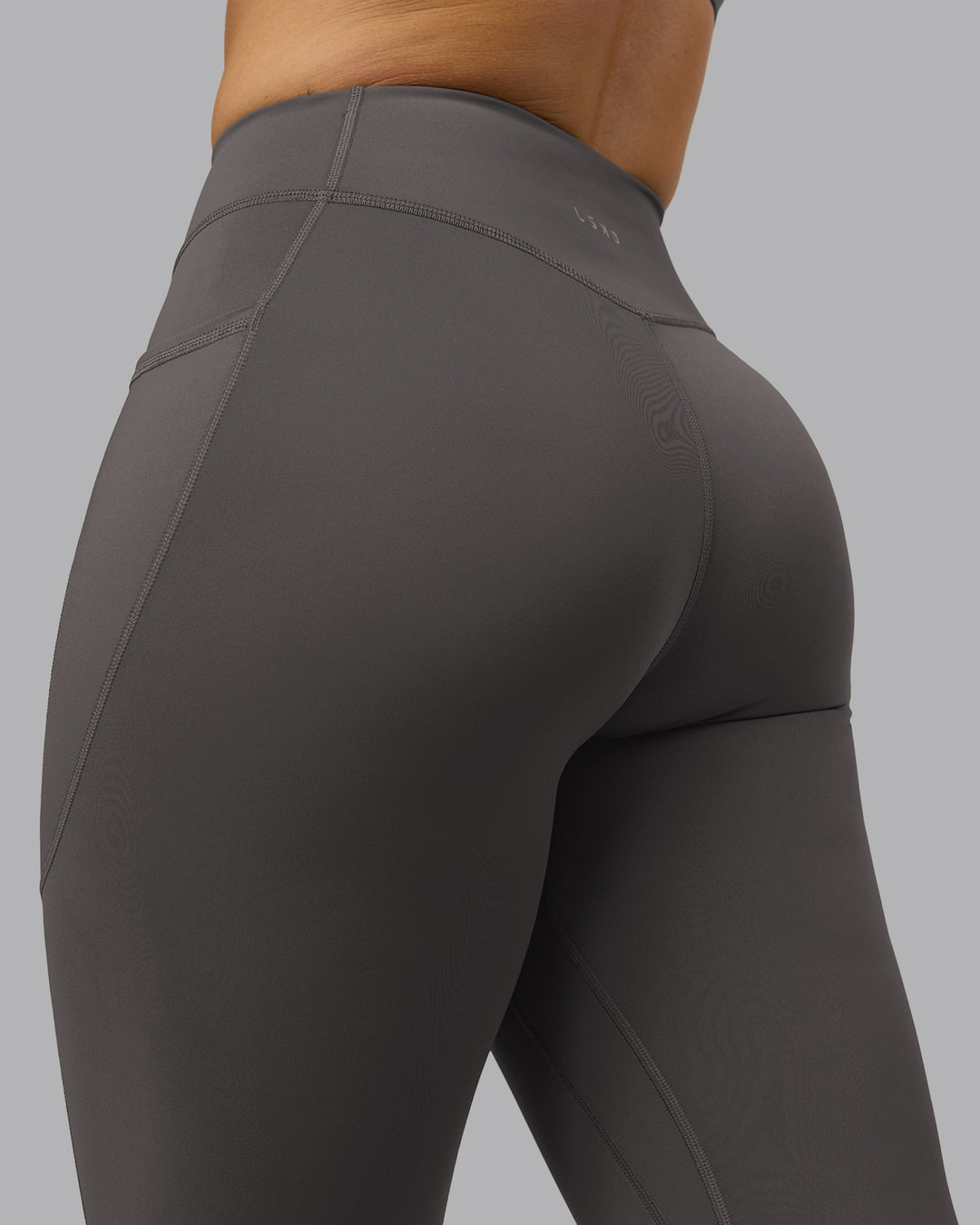 Woman wearing Elite High-Rise 7/8 Legging Pockets - Dark Storm | Model:Robyn | Size:S - view 9
