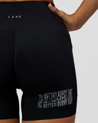 Woman wearing Elite Hype Reflective Run High-Rise 5" Short Pockets - Black-Hype Reflective | Model:Amity | Size:S | Thumbnail Index: 5