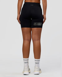 Woman wearing Elite Hype Reflective Run High-Rise 7" Short Pockets - Black-Hype Reflective | Model:Sophia | Size:S | Thumbnail Index: 4