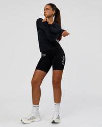 Woman wearing Elite Hype Reflective Run High-Rise 7" Short Pockets - Black-Hype Reflective | Model:Sophia | Size:S | Thumbnail Index: 8