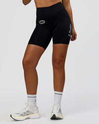 Woman wearing Elite Hype Reflective Run High-Rise 7" Short Pockets - Black-Hype Reflective | Model:Sophia | Size:S | Thumbnail Index: 2