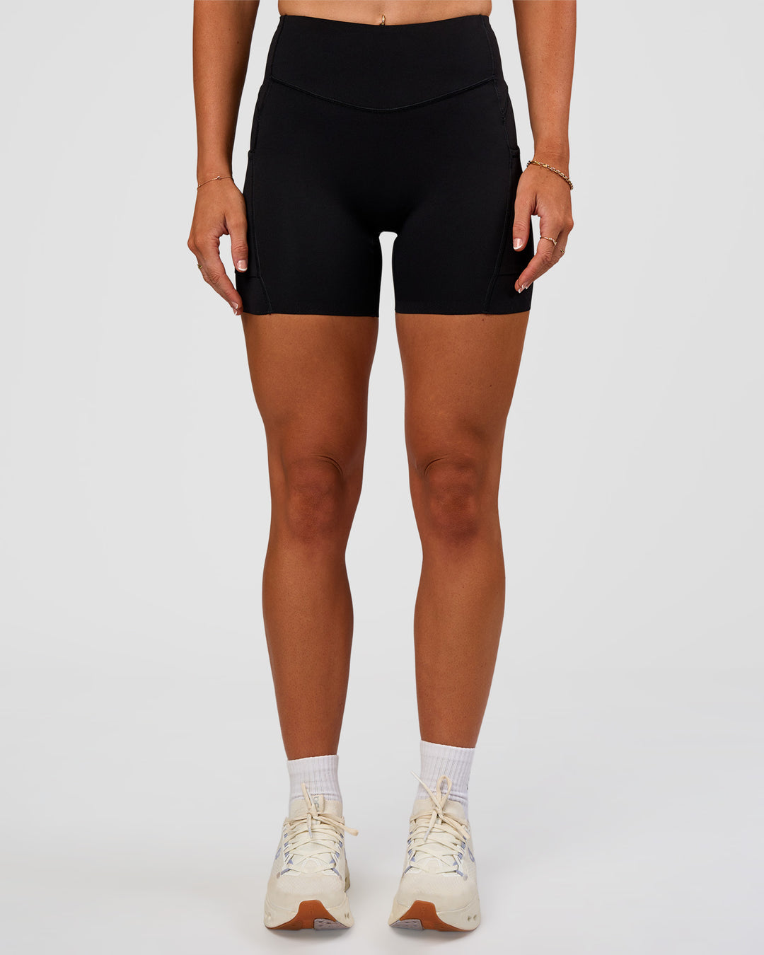 Woman wearing Elite Run High-Rise 5" Short Pockets - Black | Model:Emelia | Size:S - view 2