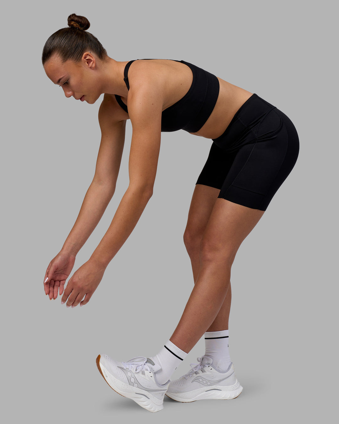 Woman wearing Elite Run High-Rise 7" Short Pockets - Black | Model:Charlize | Size:S - view 14
