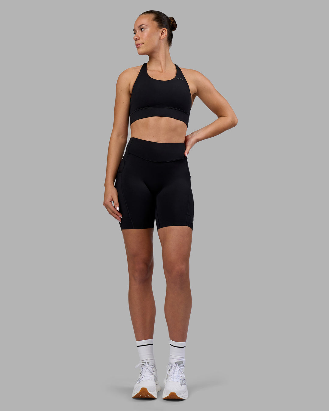 Woman wearing Elite Run High-Rise 7" Short Pockets - Black | Model:Charlize | Size:S - view 5