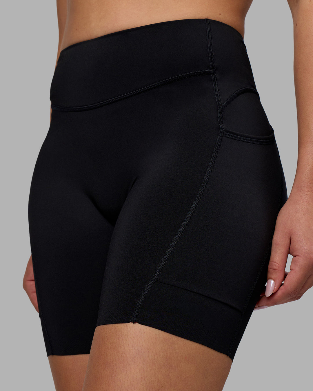 Woman wearing Elite Run High-Rise 7" Short Pockets - Black | Model:Charlize | Size:S - view 1