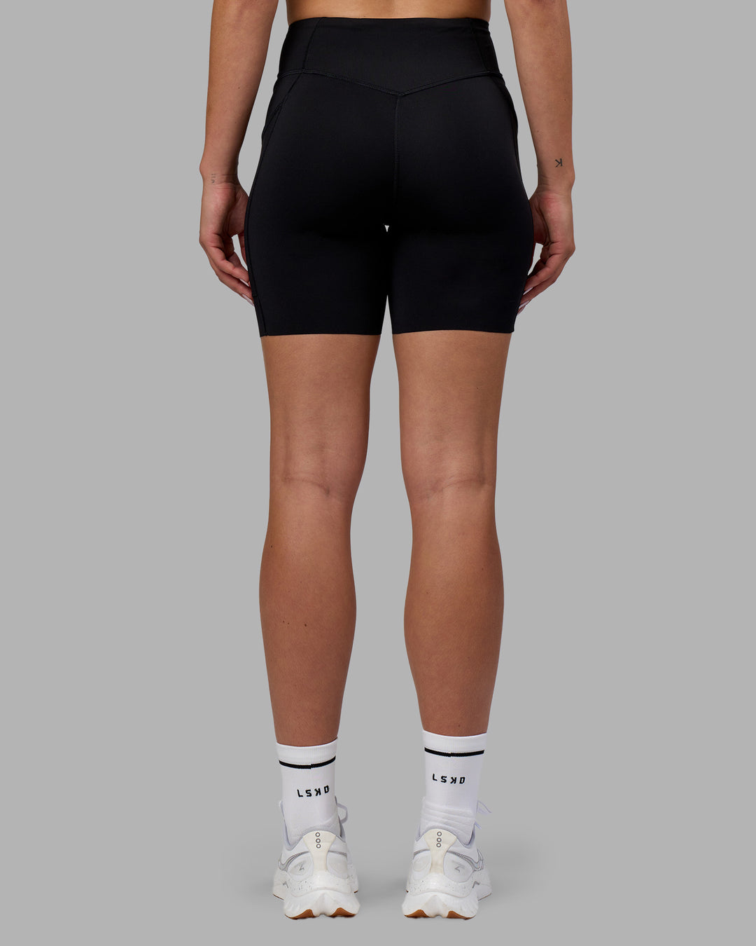 Woman wearing Elite Run High-Rise 7" Short Pockets - Black | Model:Charlize | Size:S - view 4