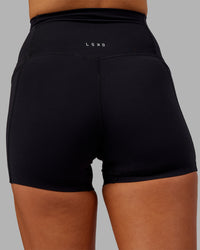 Woman wearing Elixir Ultra High-Rise 4" Short Pockets - Black | Model:Kirstyn | Size:S | Thumbnail Index: 7