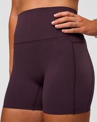 Woman wearing Elixir Ultra High-Rise 4" Short Pockets - Midnight Plum | Model:Emelia | Size:S | Thumbnail Index: 5