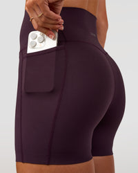Woman wearing Elixir Ultra High-Rise 4" Short Pockets - Midnight Plum | Model:Emelia | Size:S | Thumbnail Index: 0