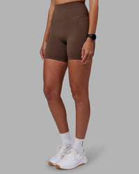 Woman wearing Elixir Ultra High-Rise 6" Short Pockets - Chocolate Martini | Model:Rhiley | Size:S | Thumbnail Index: 13