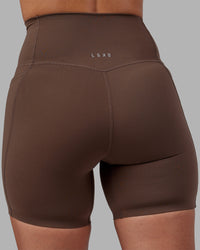 Woman wearing Elixir Ultra High-Rise 6" Short Pockets - Chocolate Martini | Model:Rhiley | Size:S | Thumbnail Index: 14