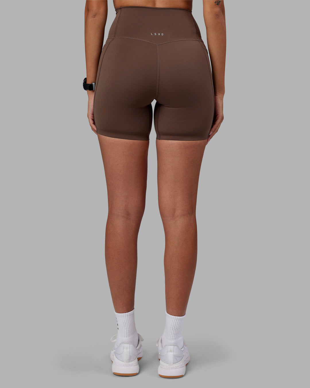 Woman wearing Elixir Ultra High-Rise 6" Short Pockets - Chocolate Martini | Model:Rhiley | Size:S - view 13