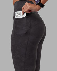 Woman wearing Elixir Ultra High-Rise 7/8 Legging Pockets - Dark Storm Wash | Model:Rhiley | Size:S | Thumbnail Index: 2