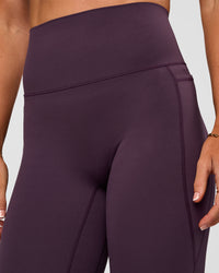 Woman wearing Elixir Ultra High-Rise 7/8 Legging Pockets - Midnight Plum | Model:Emelia | Size:S | Thumbnail Index: 10